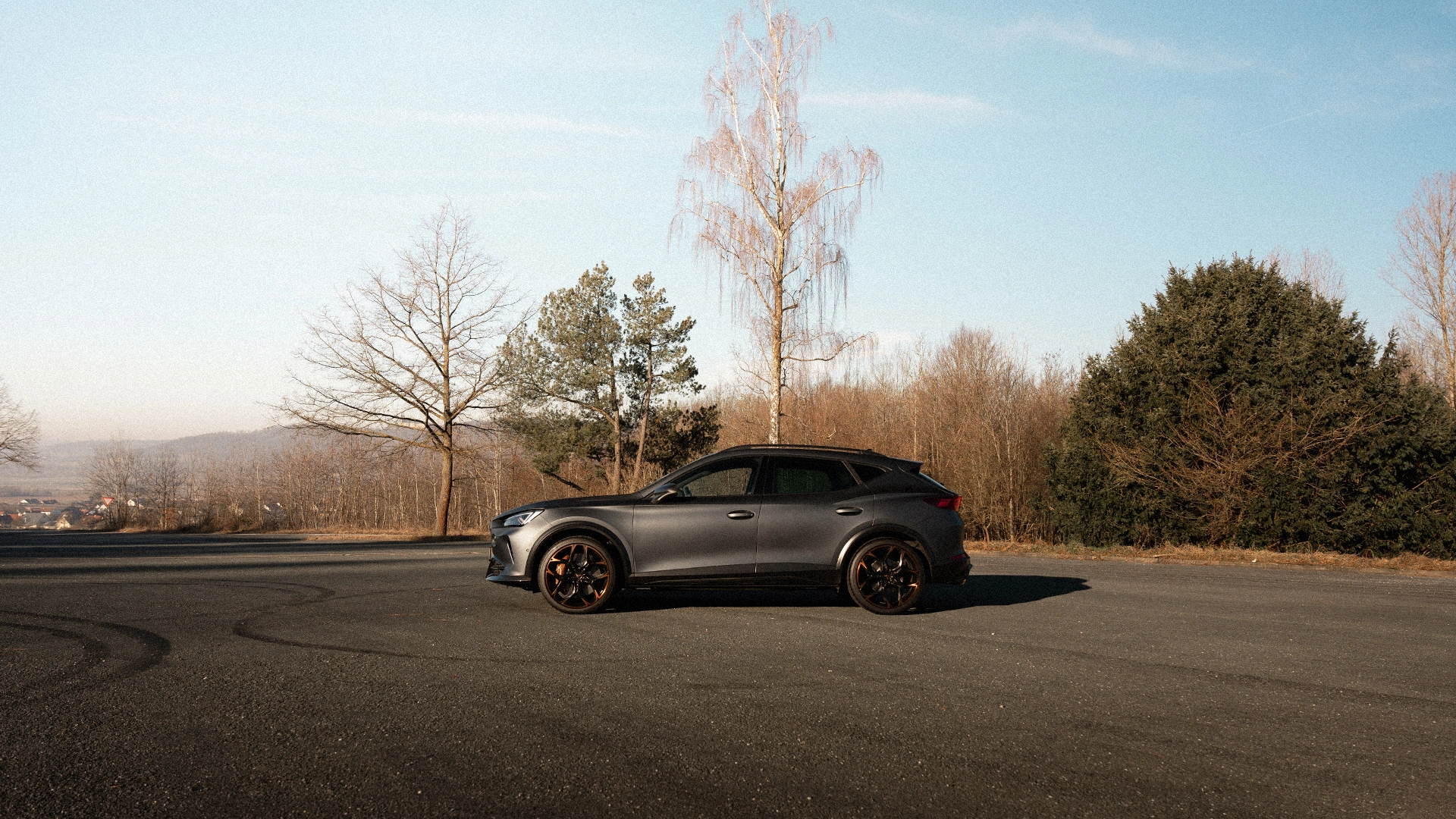 Eine Seitenaufnahme eines CUPRA CUVs, der auf einer Straße steht.