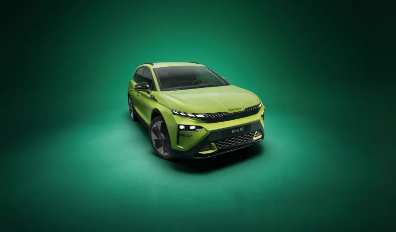 Frontalansicht eines dunkelgrünen Škoda Elroq mit AVEMO-Kennzeichen vor hellem Hintergrund. Das Elektro-SUV präsentiert das neue „Tech-Deck Face“ Design mit geteilten LED-Scheinwerfern und dem markanten Škoda-Schriftzug auf der Motorhaube.