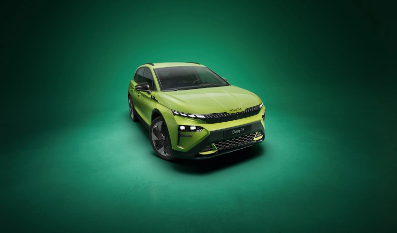 Frontalansicht eines dunkelgrünen Škoda Elroq mit AVEMO-Kennzeichen vor hellem Hintergrund. Das Elektro-SUV präsentiert das neue „Tech-Deck Face“ Design mit geteilten LED-Scheinwerfern und dem markanten Škoda-Schriftzug auf der Motorhaube.