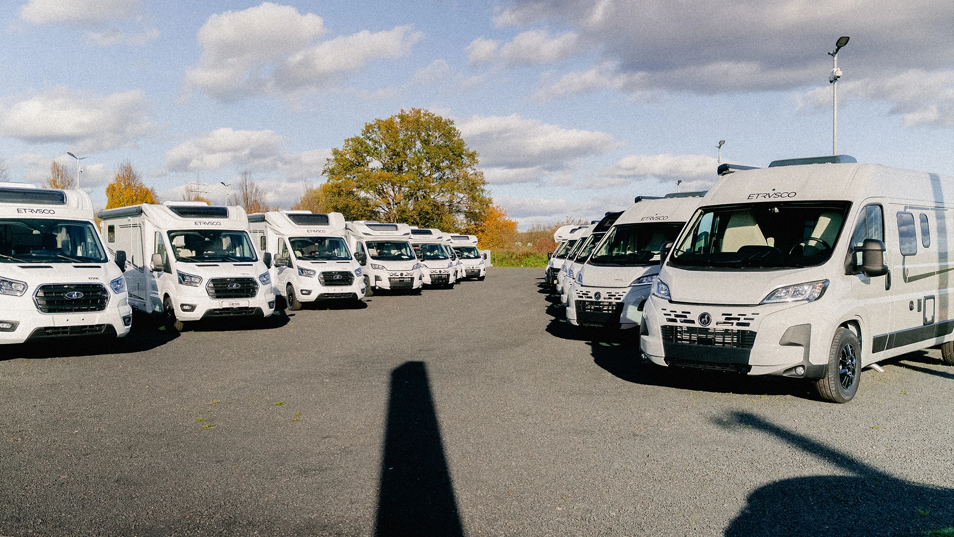 Eine Aufnahme von Etrusco Wohnmobilen, die auf einem Schotterplatz stehen.