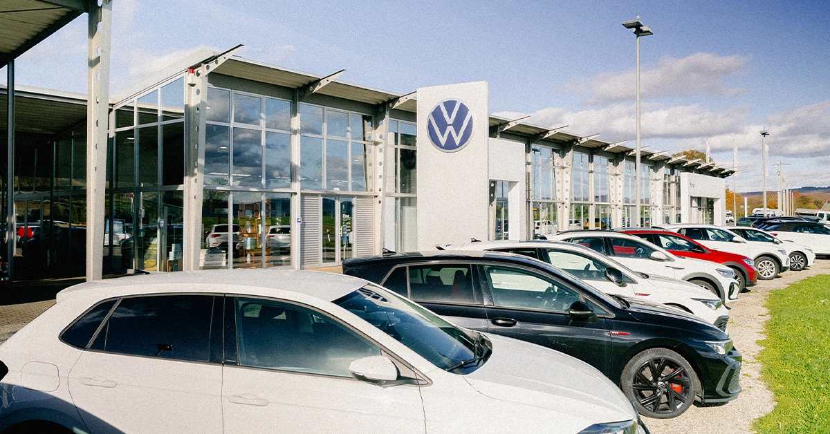 Eine Aufnahme des Volkswagen & Etrusco Autohauses in Büdingen, die das Gebäude und Volkswagen Fahrzeuge vor dem Gebäude zeigt.