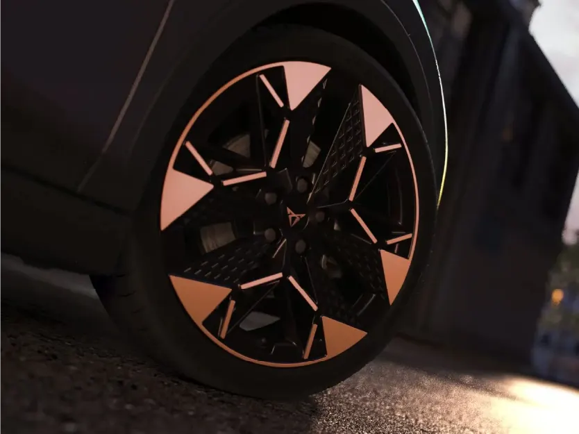 Nahaufnahme einer aerodynamischen Cupra-Leichtmetallfelge in Schwarz mit markanten kupferfarbenen Einsätzen. Das Cupra-Logo ziert die Radmitte. Die Felge steckt auf einem Niederquerschnittsreifen, der auf dunklem Asphalt steht.