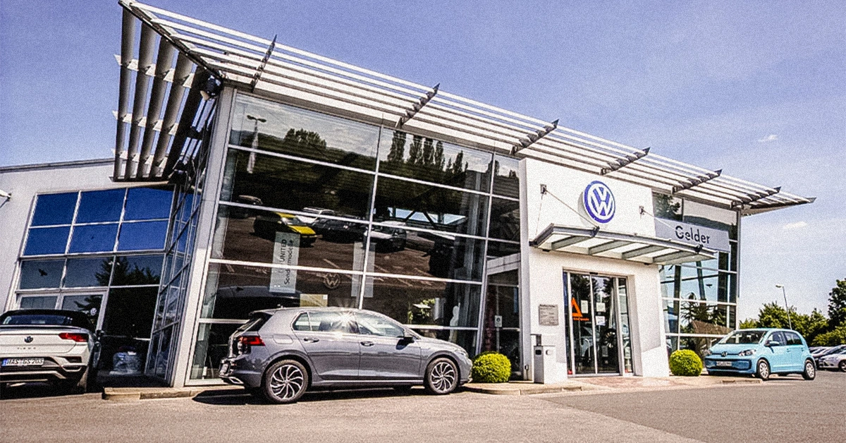 Eine Aufnahme des Volkswagen Autohauses in Haßfurt, die das Gebäude und Volkswagen Fahrzeuge vor dem Gebäude zeigt.