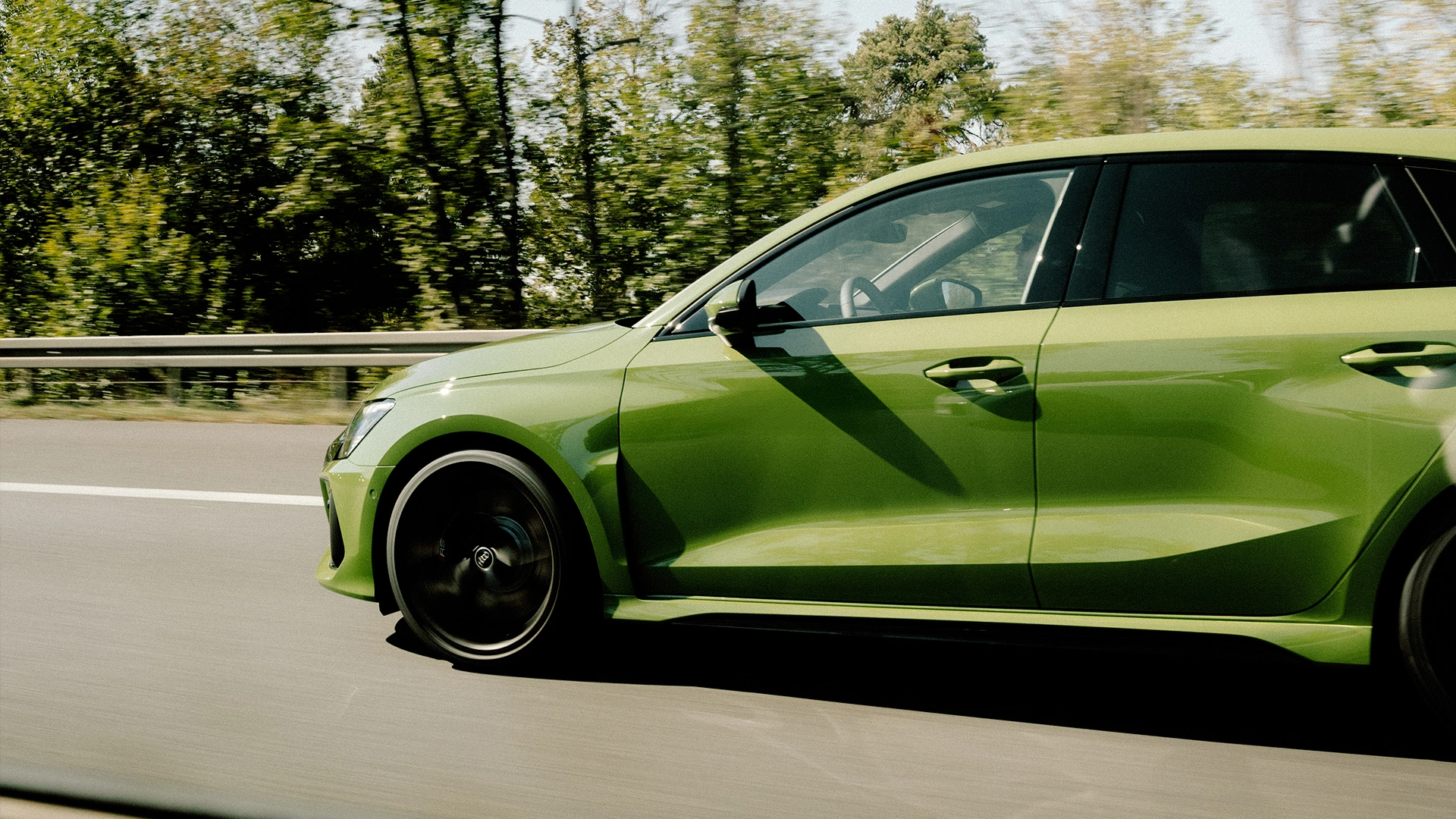 Fahrzeug fahren Eine seitliche Aufnahme eines grünen Fahrzeugs, das auf der Autobahn fährt.