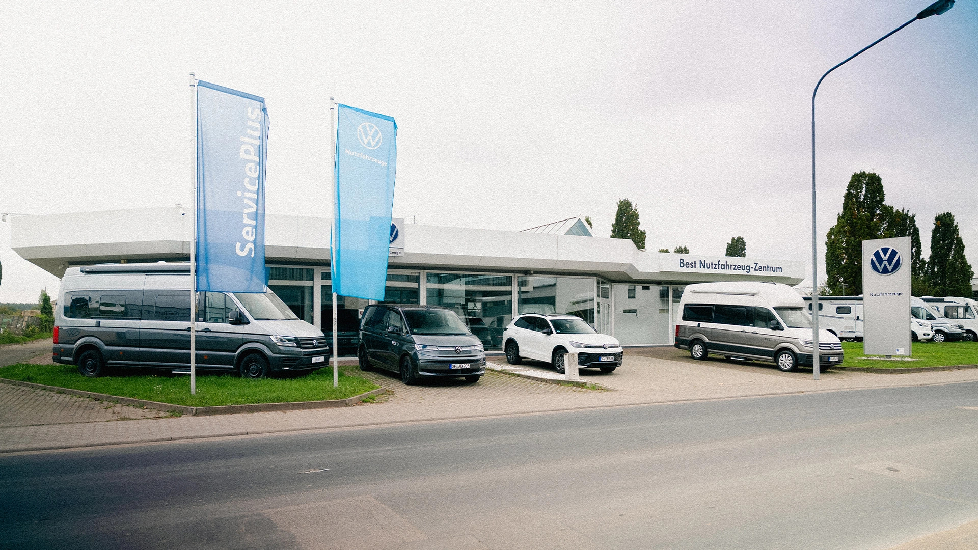 Eine Aufnahme des Volkswagen Nutzfahrzeuge Autohauses in Mühlheim am Main, dass die Gebäude und Volkswagen Nutzfahrzeuge vor dem Gebäude zeigt.