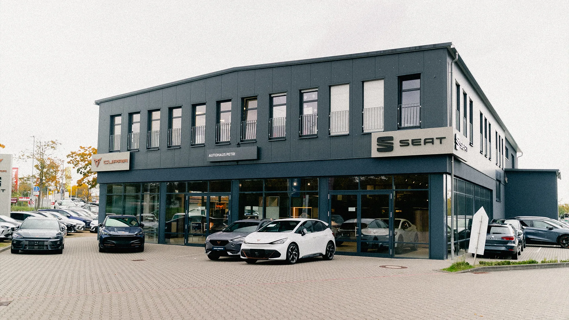 Eine Aufnahme des SEAT und CUPRA Autohauses in Hofheim am Taunus, dass die Gebäude und SEAT und CUPRA Fahrzeuge vor dem Gebäude zeigt.