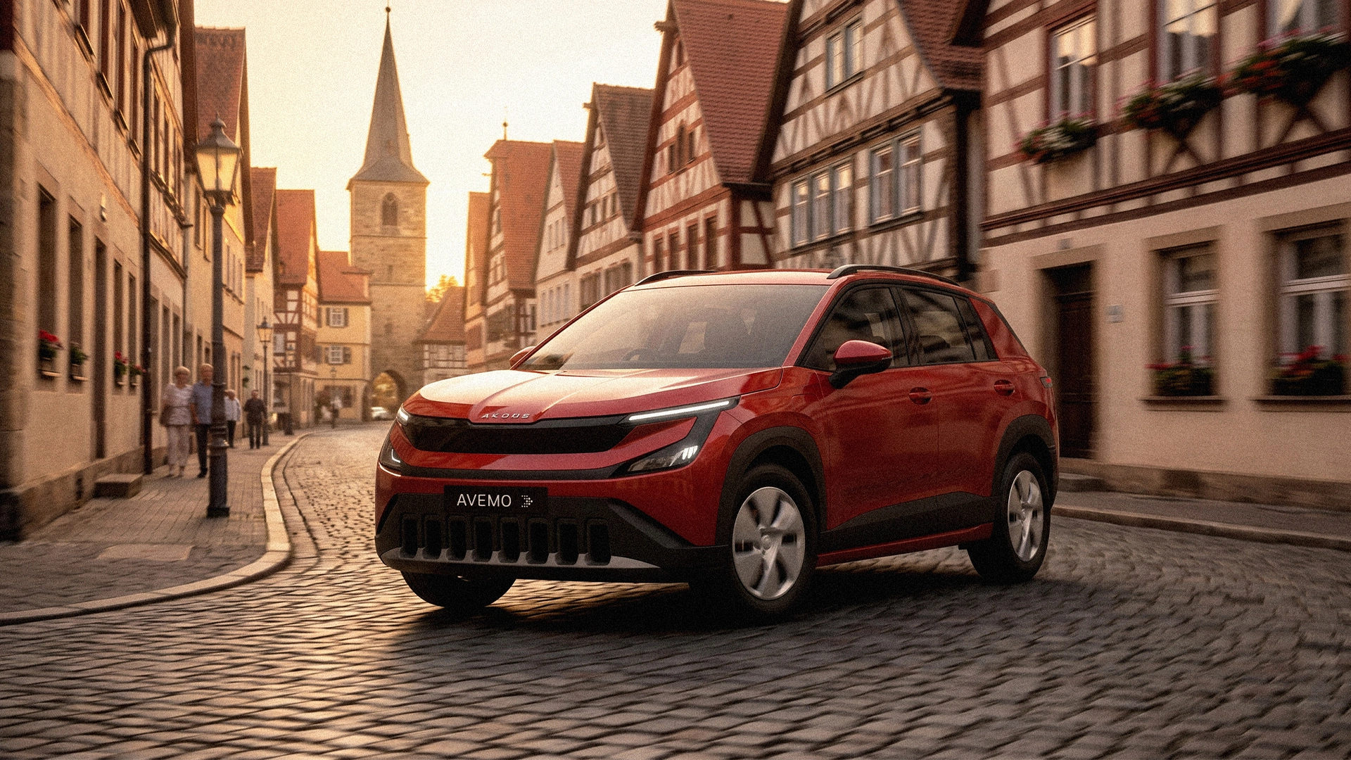 Ein roter Škoda Epiq fährt im warmen Sonnenlicht auf einer Kopfsteinpflasterstraße durch eine historische Altstadt mit Fachwerkhäusern und einem Kirchturm im Hintergrund.
