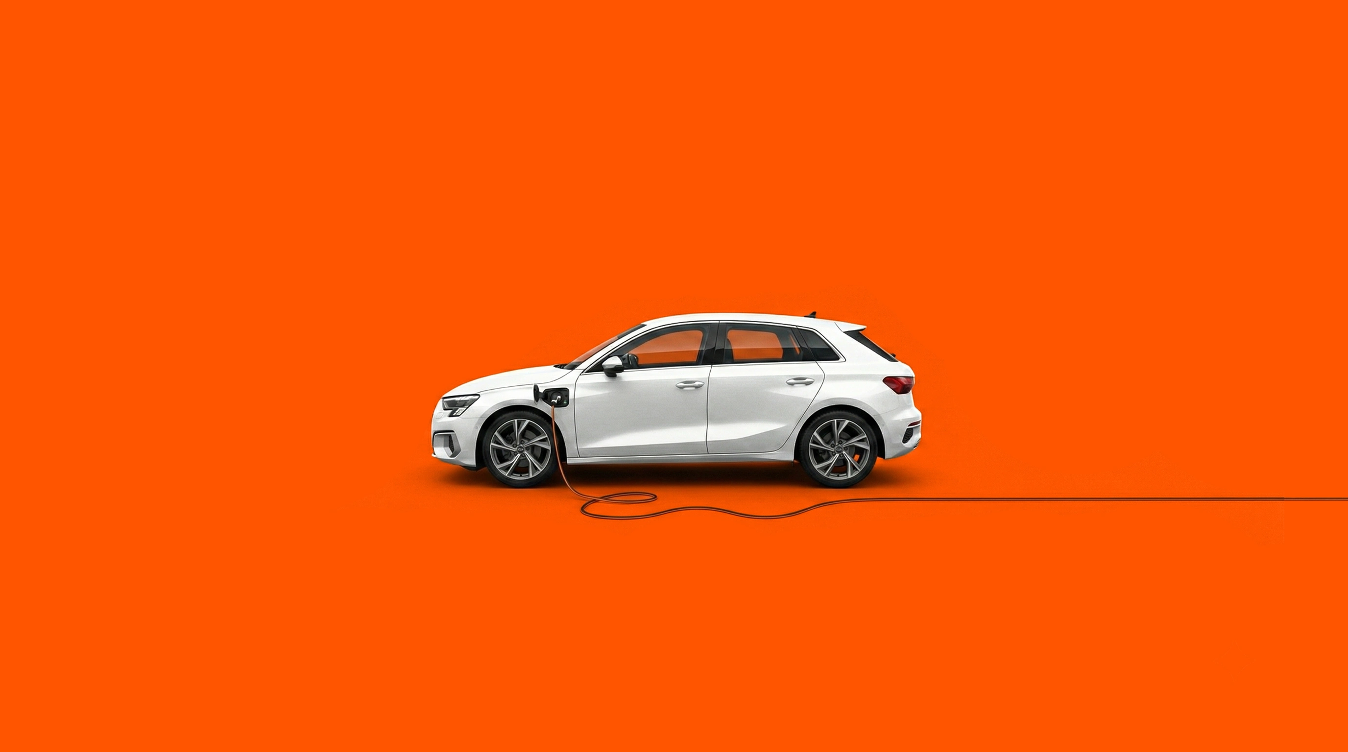 26-016 Elektroförderung Header2 Seitenansicht eines weißen Audi A3 beim Ladevorgang vor einem leuchtend orangefarbenen Hintergrund. Das Ladekabel ist am vorderen Kotflügel eingesteckt und verläuft flach über den Boden.