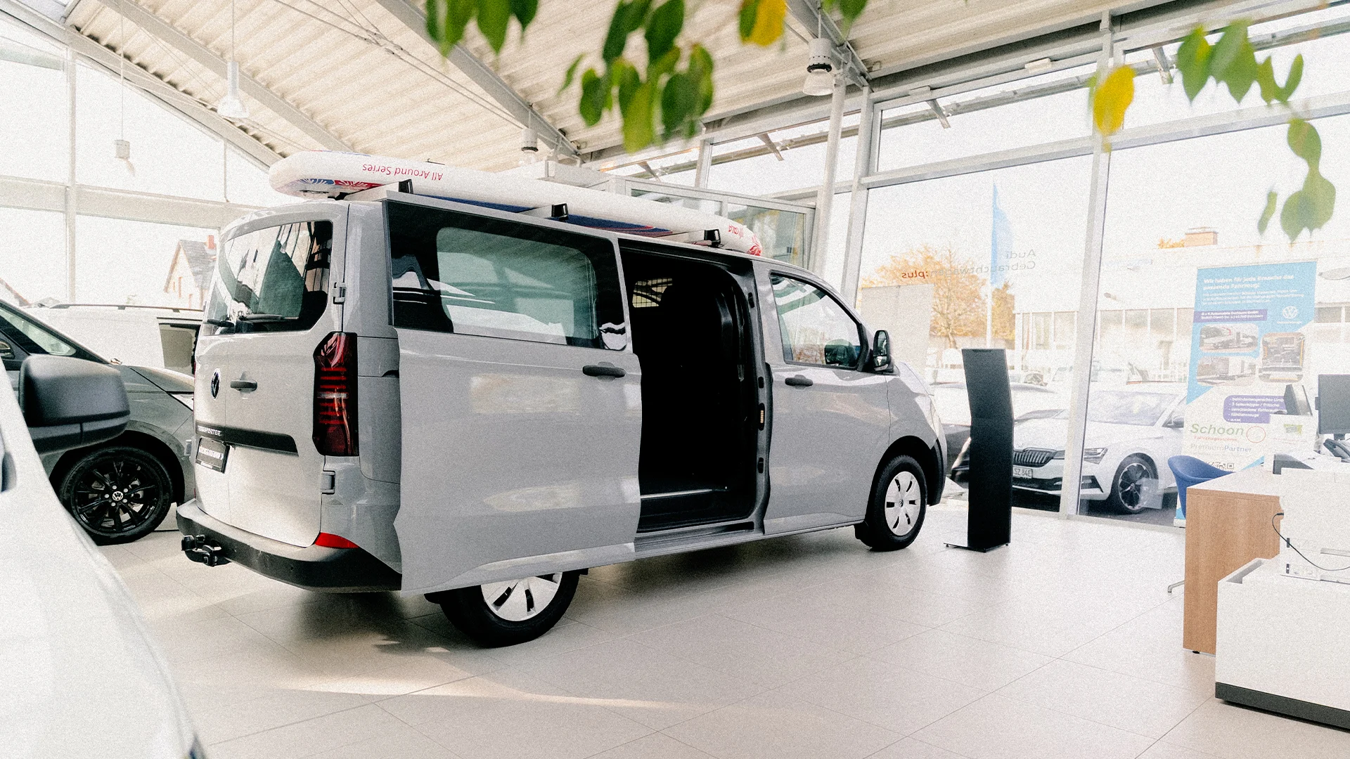 Eine Aufnahme eines Campers von Volkswagen Nutzfahrzeuge, der im Autohaus im Showroom ausgestellt ist.