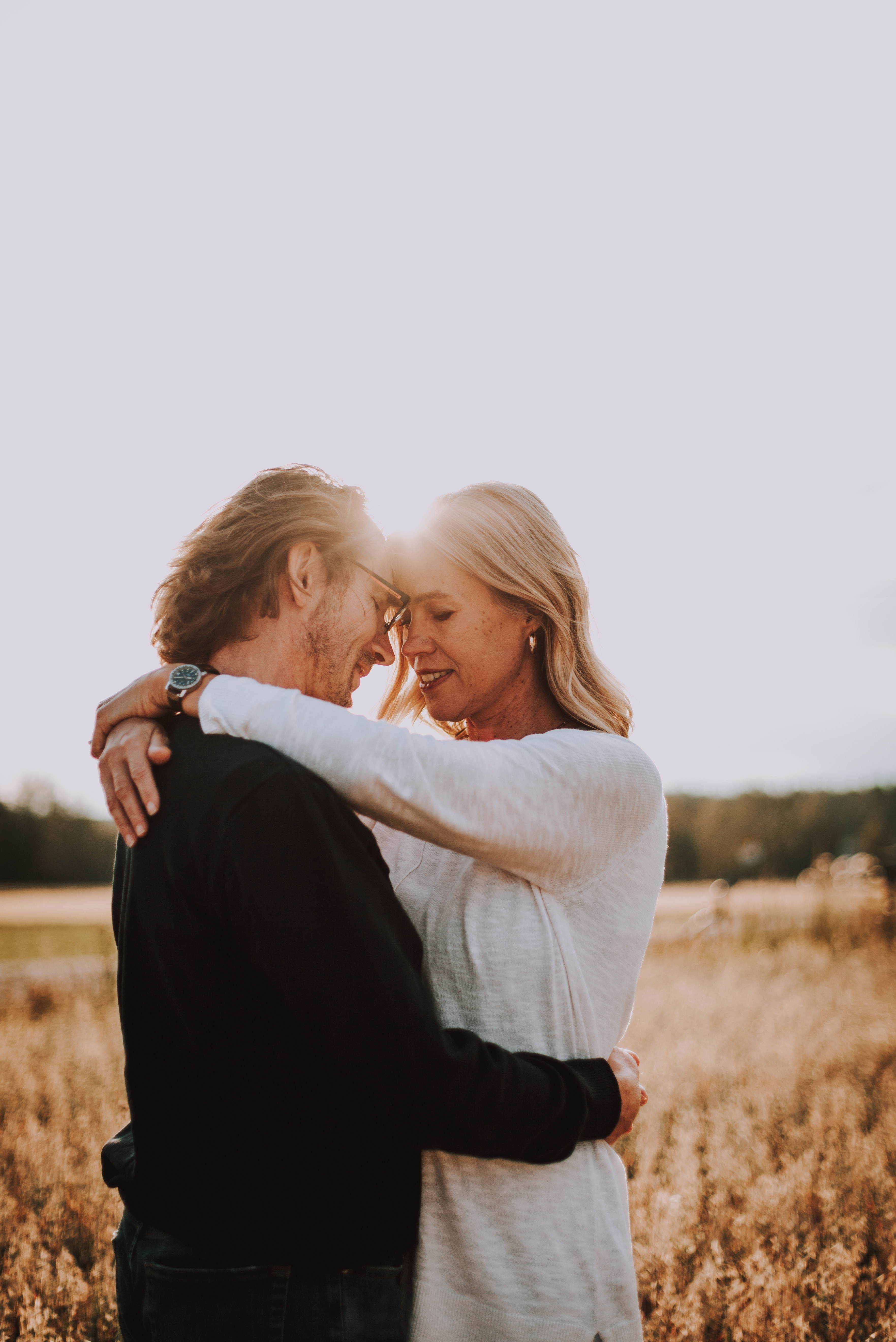 Pari ilta-auringossa pellolla parikuvauksessa tai potrettikuvauksessa Vantaalla