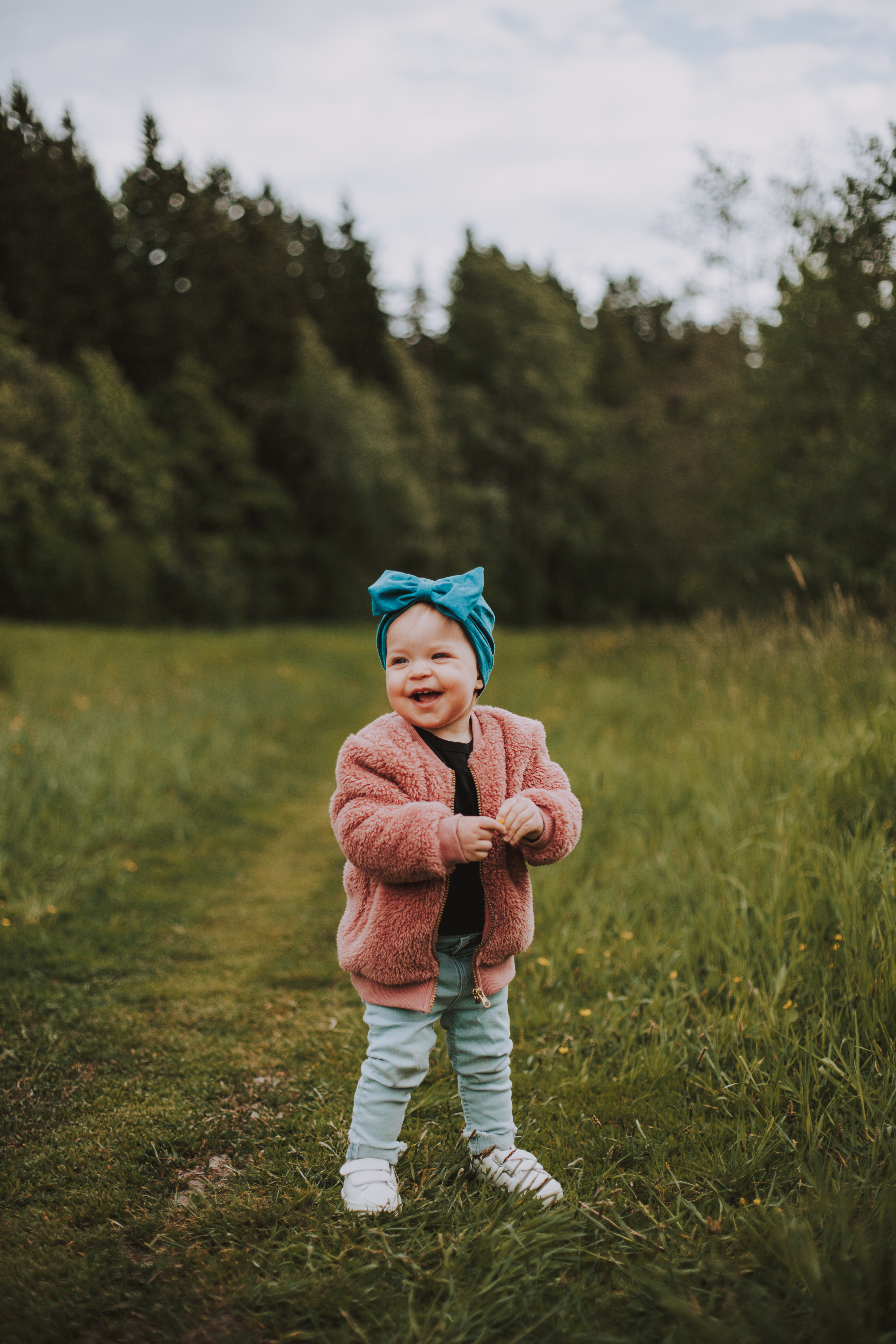 Naurava lapsi pellolla kesällä perheen miljöökuvauksessa