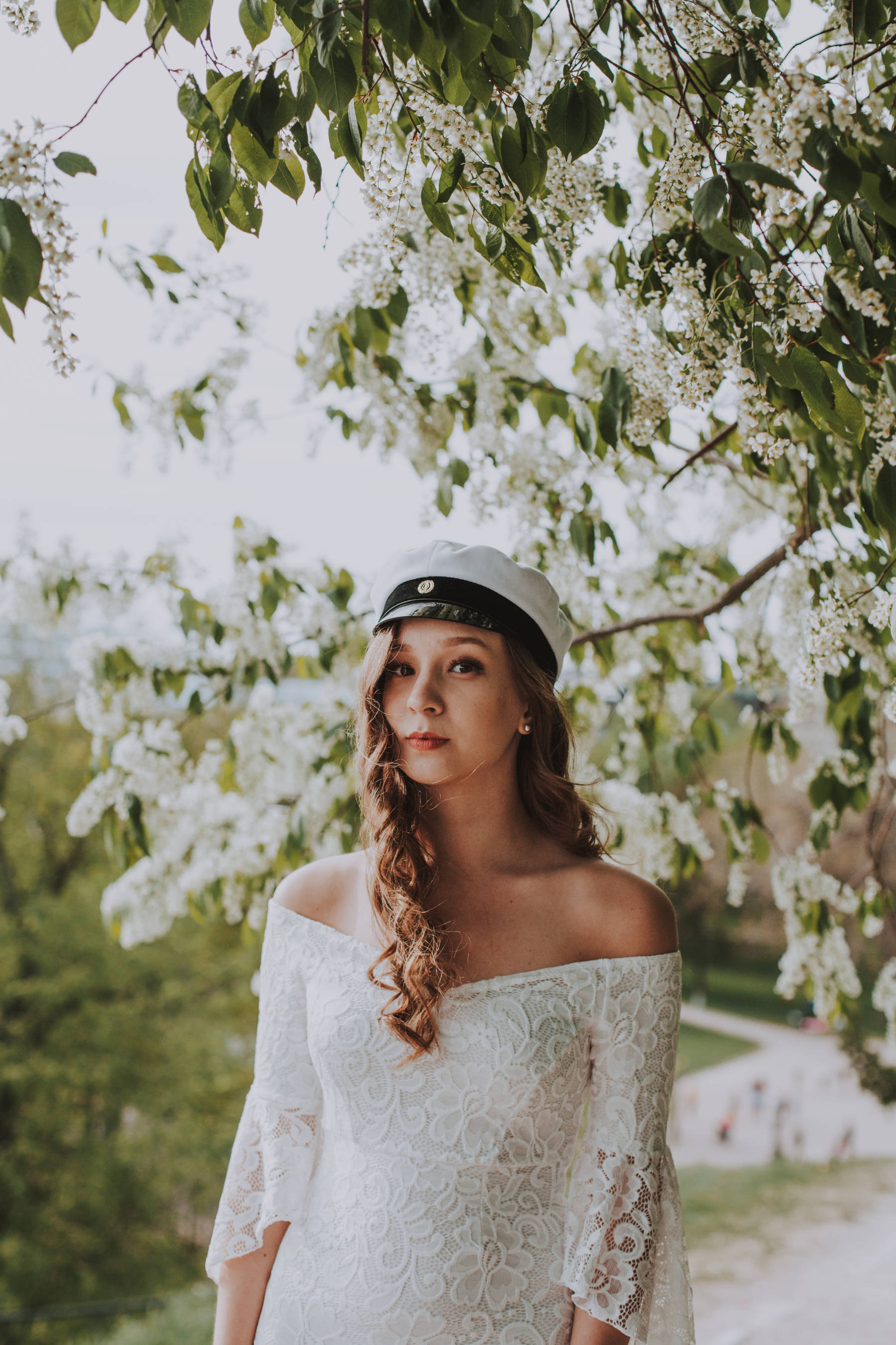Tytto ylioppilaskuvauksessa Kaivopuistossa Helsingissa kesalla valkoinen mekko paalla