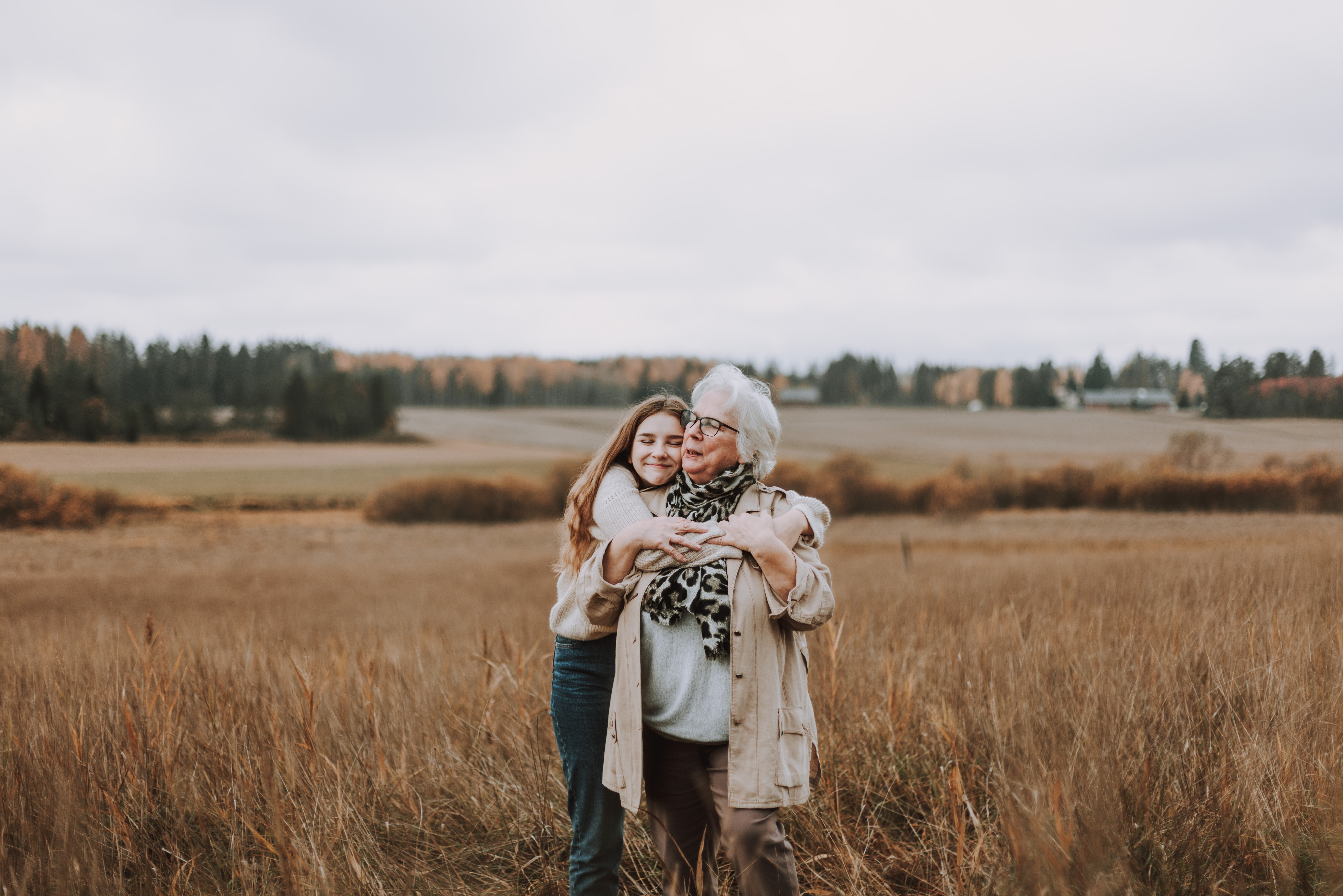 Tyttö halaa isoäitiä miljöökuvauksessa pellolla