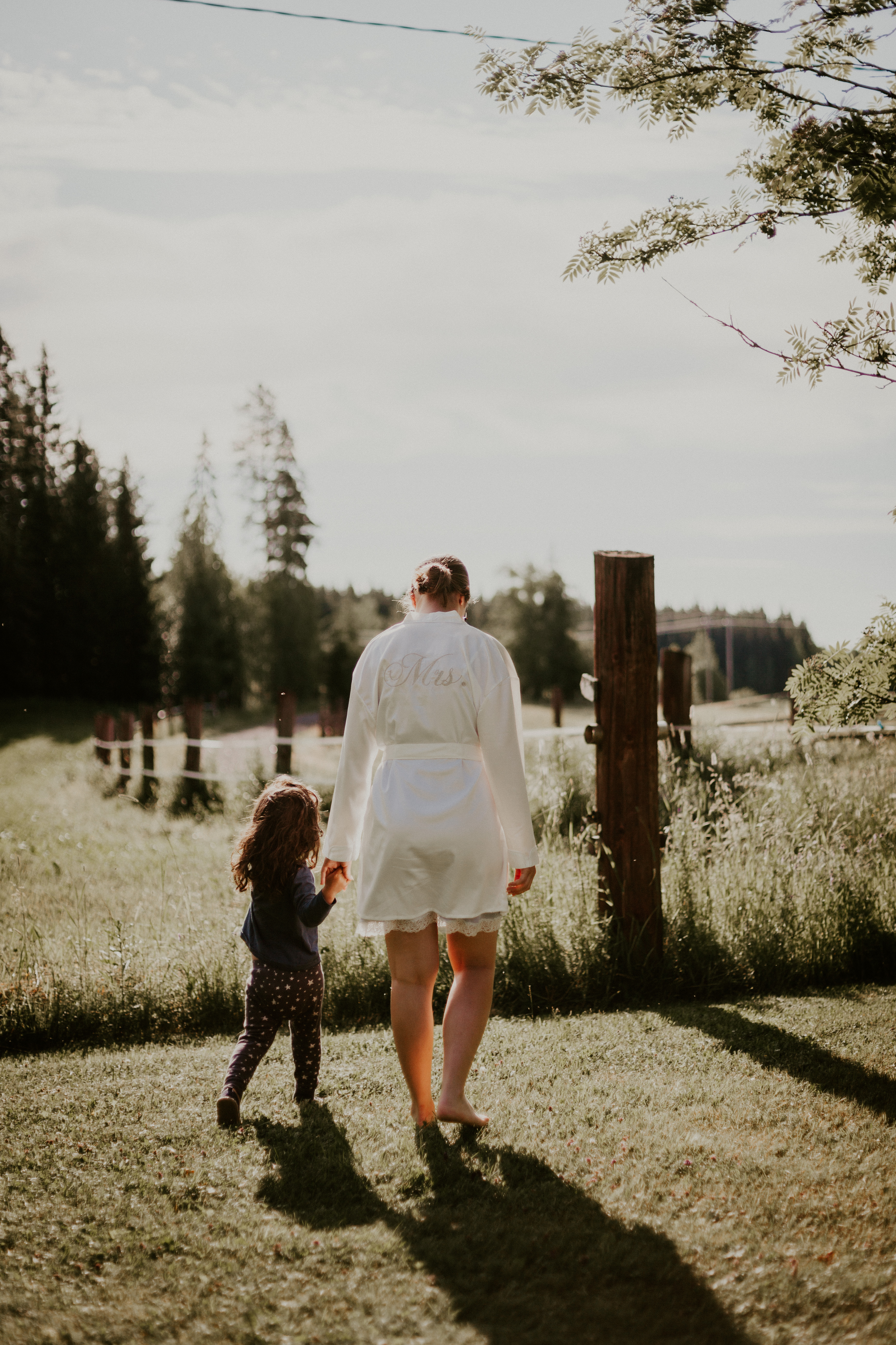 Morsian hääaamuna aamutakissa ulkona kukkaisneidon kanssa