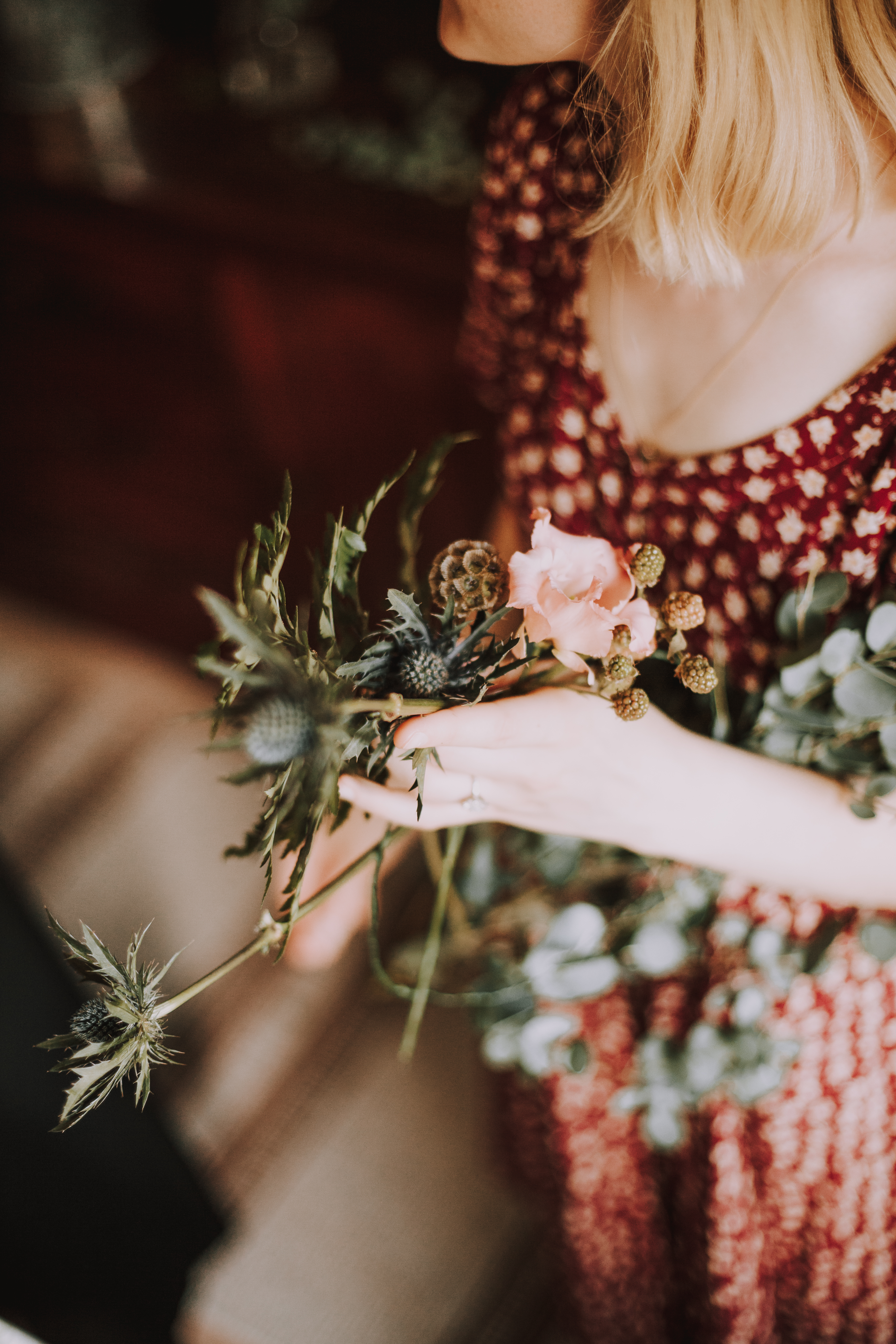 Nainen pitää kädessä kukkaseppeleen tarvikkeita polttareissa