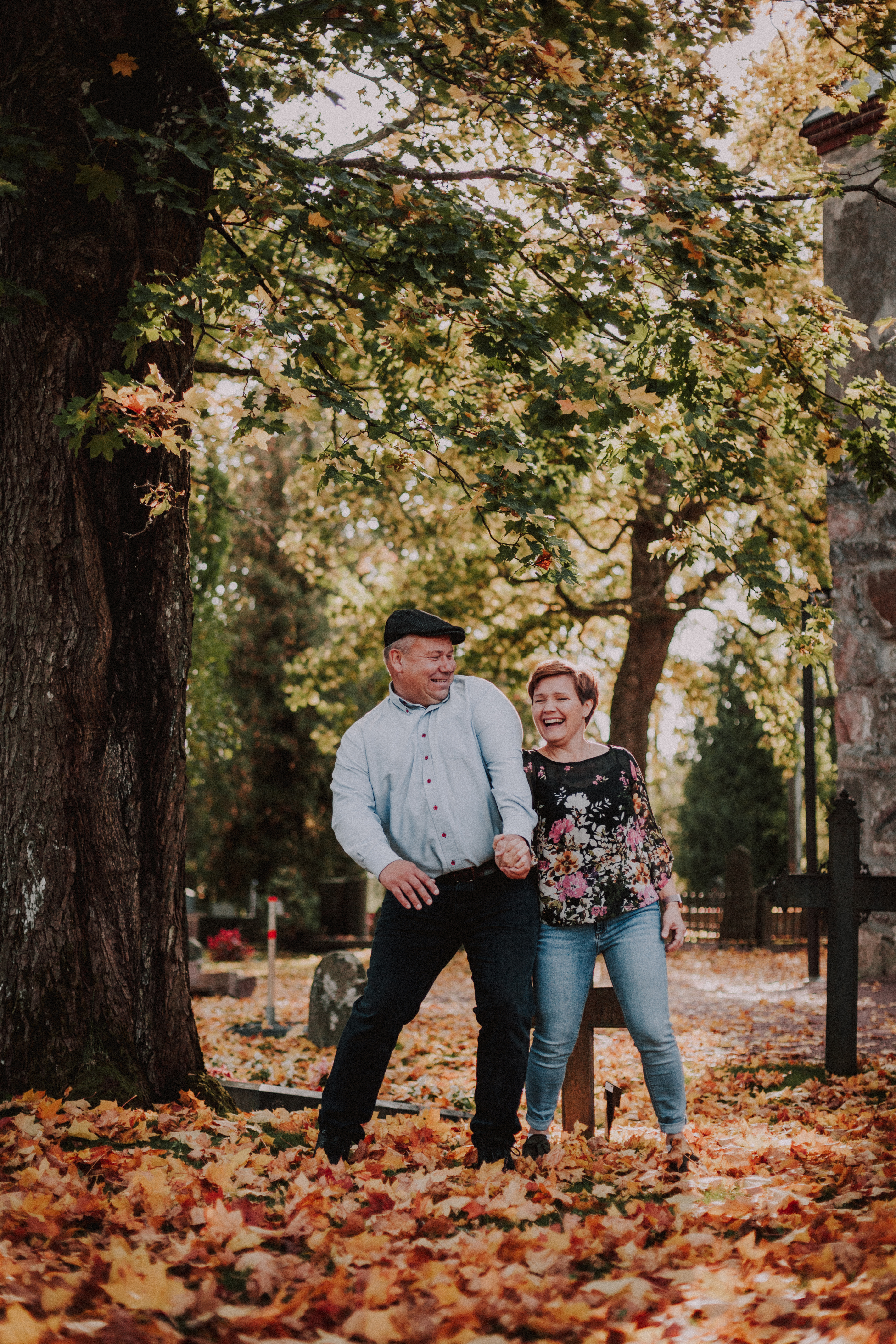 Pariskunta syksyn parikuvauksessa tai potrettikuvauksessa Pyhän Laurin kirkolla Vantaalla