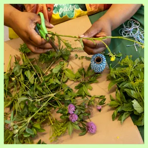 An adult and 2 children planting seeds in a garden