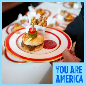 A plated slider with fries is served at a table, highlighting a small bite from a culinary event.