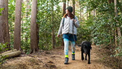 A woman walks with her dog on a scenic trail through the woods thinking of how to make a house a home.