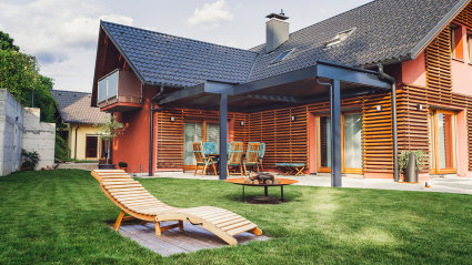 A wooden vacation home with a lawn and fire pit.