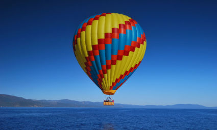 A hot air balloon soars above Lake Tahoe in summer.