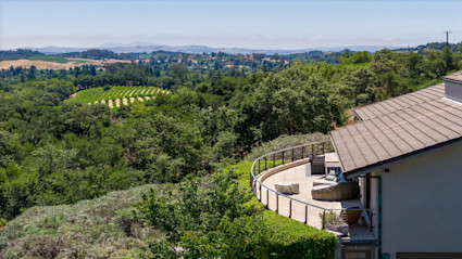 Modern patio with vineyard views, representing the exclusive lifestyle of summer in Napa’s wine country estates.