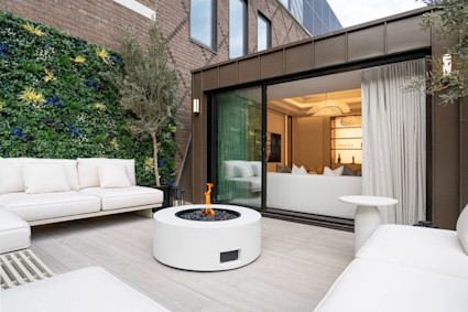 Courtyard with white furniture, a fire pit.