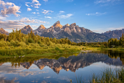 The Tetons reflect the year-round draw of Jackson Hole, from powder days to summer trail adventures.