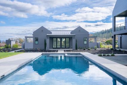 Outdoor pool and pool house on a partly cloudy day