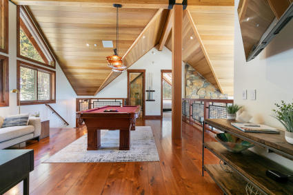 Living room with vaulted wood ceilings and a pool table