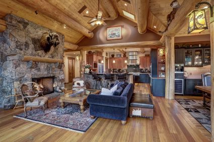 wood cabin living room with fireplace and open concept floor plan