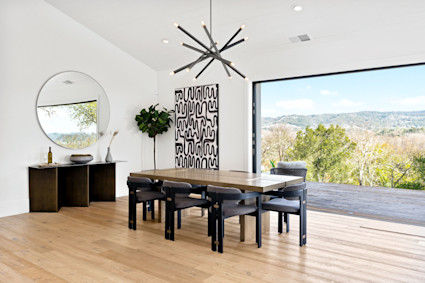 Stylish dining area with a modern chandelier and wood flooring, reflecting the convivial atmosphere of Sonoma's harvest feasts.