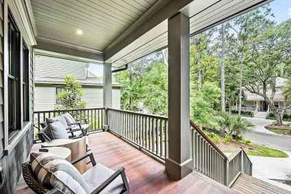 Outdoor seating area of a Kiawah Island Pacaso vacation home featuring a wooden porch with chairs