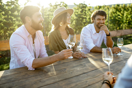 Festival guests enjoy wine at a vineyard table, reflecting the social and festive spirit of summer in Napa Valley.