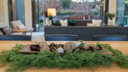 A tray with pinecones resting on a table surrounded by pine leaves.