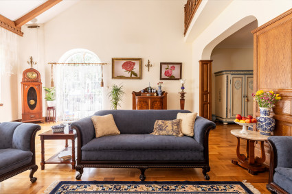 A living room with traditional touches and lots of color is decorated in a French country style, a popular type of interior design.