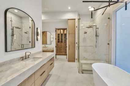 An elegant ensuite bathroom with a large tub and a walk-in shower