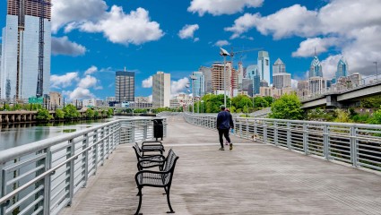 Downtown Philadelphia sits in the distance of the riverwalk, a great activity for pet-friendly vacations to the city.