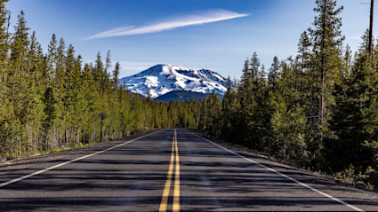 A winding road outside Bend, Oregon, directs hikers and nature lovers into forests decorated with autumn color. This image evokes the thrill of a day spent exploring the Cascades before returning to a welcoming mountain home.