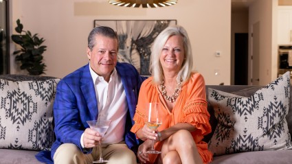 A couple sits on a couch enjoying a cocktail in their second home.