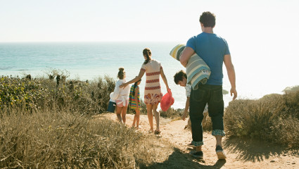 A family walks to the beach at one of the best family vacation spots.