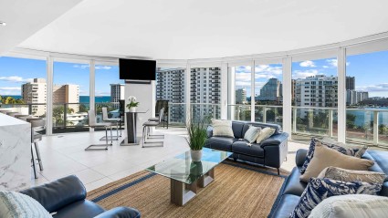 Living room with a wall of curved glass and skyline views