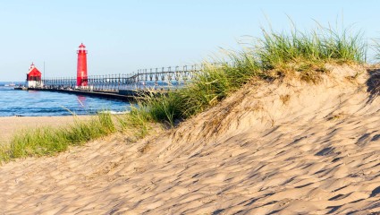 A lighthouse sits just off the shore of Grand Haven, Michigan, one of the great destinations for pet-friendly vacations.