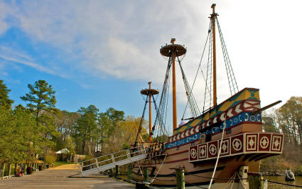 A cannon guards the entrance to a wood-framed hut in Jamestown, one of the best spring break ideas for families.