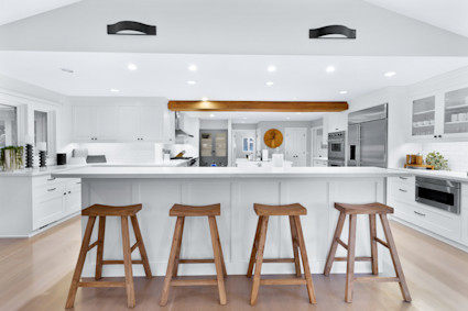 A modern kitchen with a wall chimney range hood and high-end appliances, showcasing the culinary focus in luxury real estate in Sonoma's wine country.