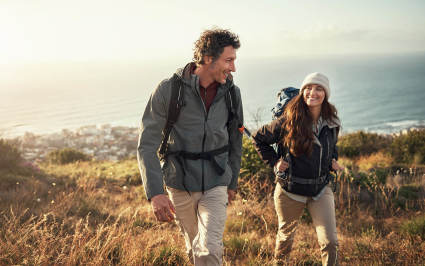 Two people go on a hike while enjoying a luxury vacation.