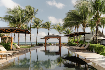 Villa BOM, Pacaso home in St-Barthélemy — pool pavilion with palms and ocean (Villa-BOM-Pacaso-StBarth-Jan-2026-FUJI7155, photo © Tisa Sencur). Cropped 3:2 from the 8000px original with sky trimmed to keep the pool fully in frame. How It Works page hero.