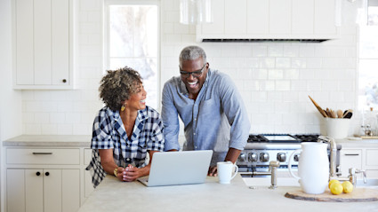 couple in kitchen looking at laptop
