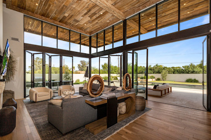 A sun-filled living room with wood accents in Scottsdale, AZ, offering a private atmosphere that connects seamlessly to the surrounding landscape.