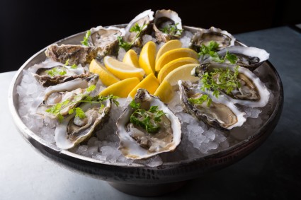 Platter of raw oysters with lemon and ice